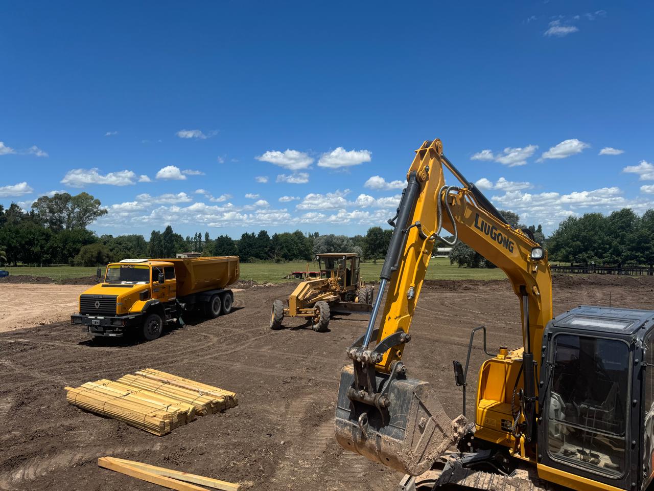Excavadora, motoniveladora y camión volcador de Todo Vial trabajando en un predio