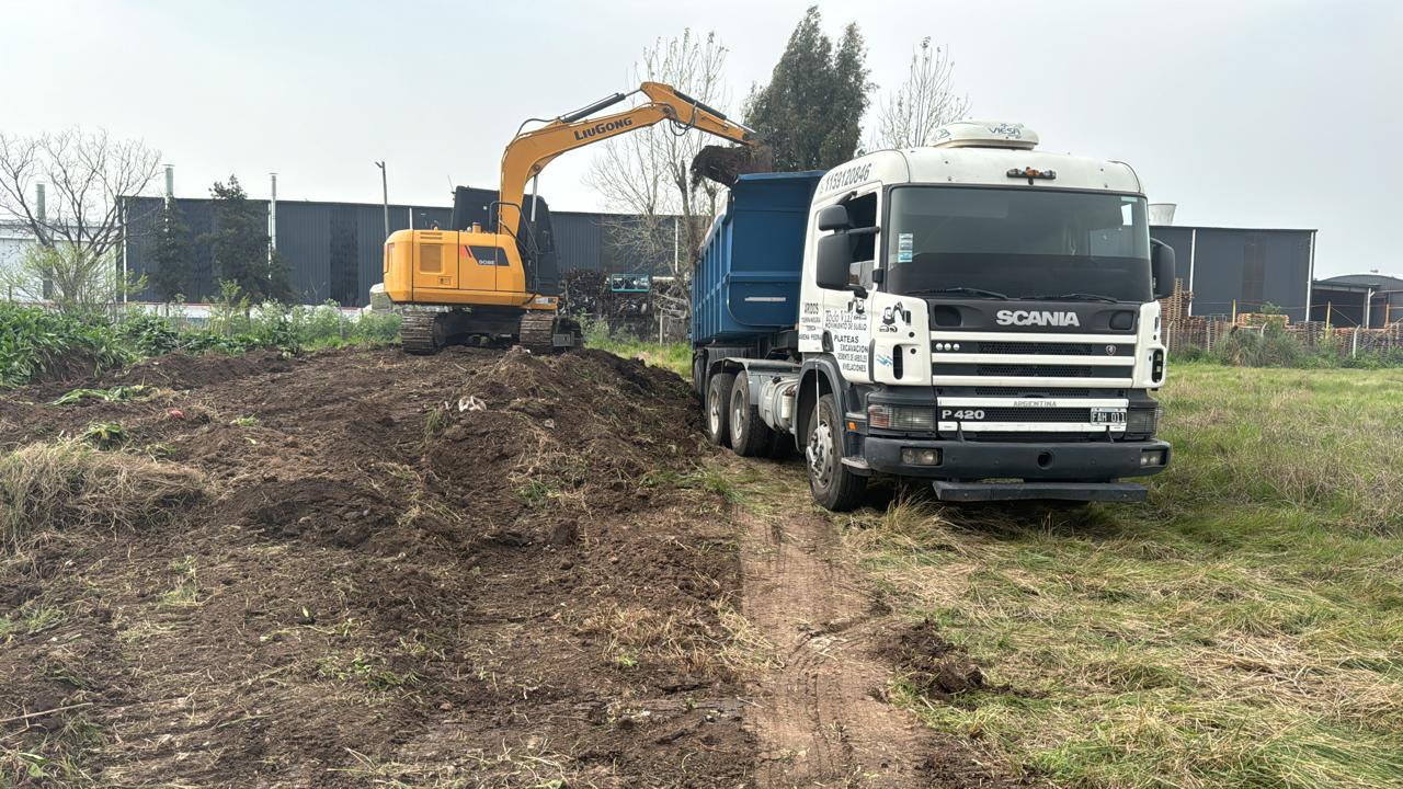 Excavadora cargando tierra en un camión Scania con caja volcadora