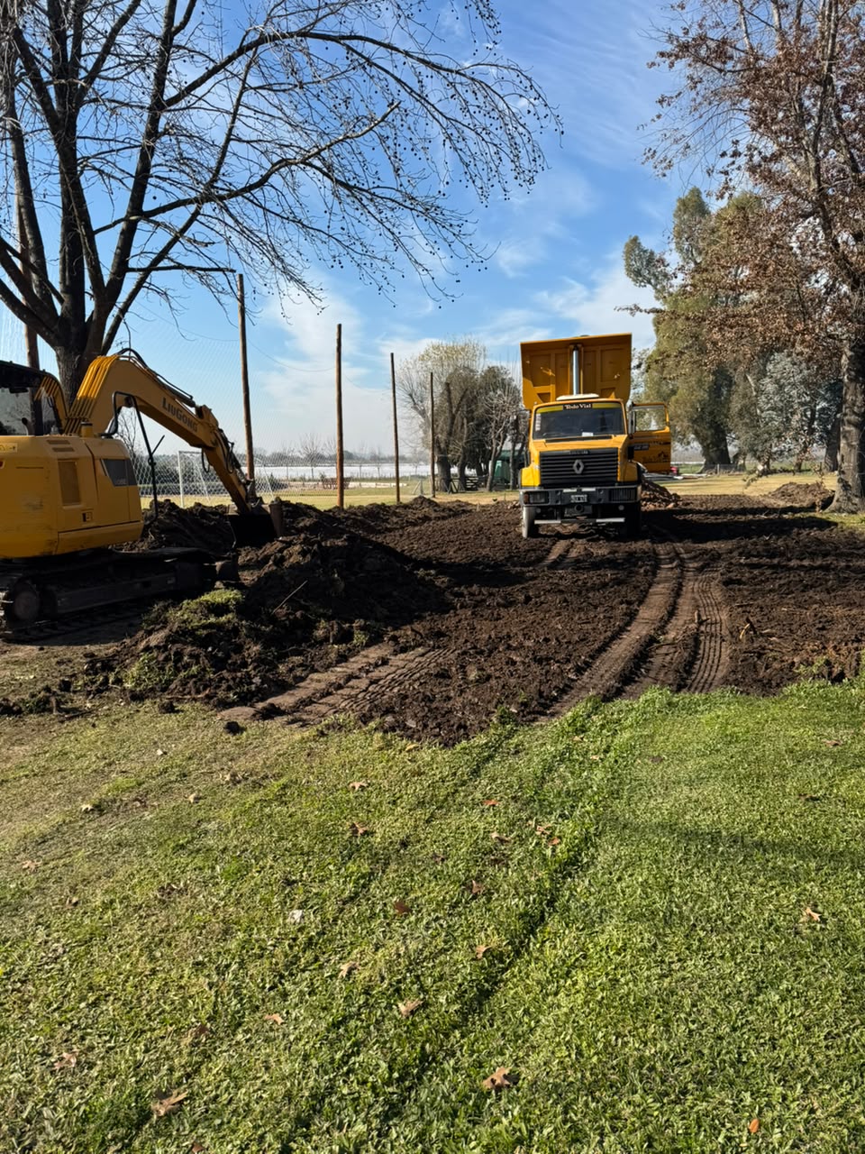 Excavadora cargando tierra en un camión volcador durante una excavación